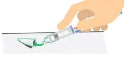 A hand holding a syringe with dark liquid and removing the green protective cap from the tip of the