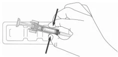A hand holding a syringe with two black arrows indicating the required pressure on the sides of the device body for activation