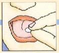 Una mano inserisce una piccola compressa bianca