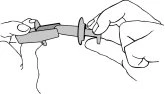 Two hands holding and separating components of a prefilled syringe for drug preparation