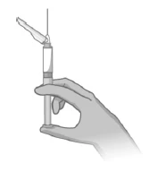 Una mano sostiene verticalmente una jeringa lista para su uso