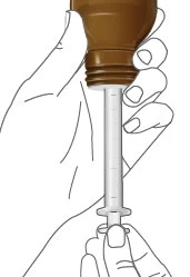 A hand holds the upper part of a brown syringe while the