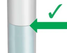 Detail of a cylindrical medical device with a green arrow pointing to the junction between the upper white and lower blue part, with a green checkmark
