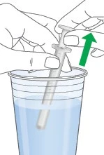 Two hands hold a syringe to withdraw liquid from a glass container