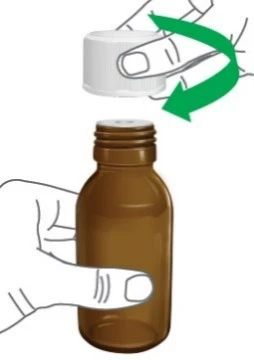A hand holds an amber vial while the