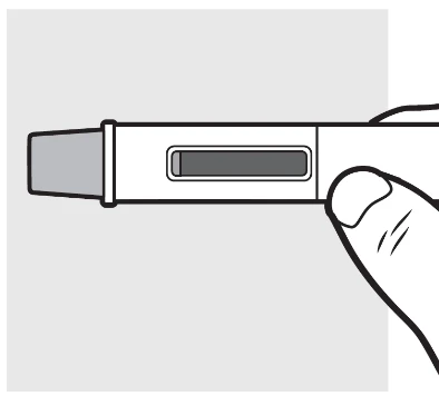 Una mano sostiene horizontalmente un dispositivo médico blanco con una ventana rectangular central que muestra el contenido interno