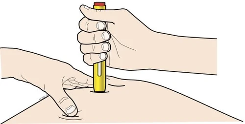 Una mano sostiene un inyector amarillo en posición vertical mientras la