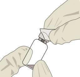 Две руки в перчатках держат белый стеклянный флакон с серой пробкой для приготовления лекарства