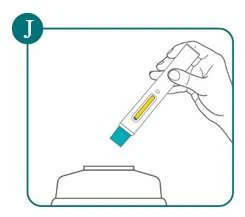 Una mano sostiene un dispositivo médico cilíndrico con un indicador amarillo sobre una base plana blanca y azulada