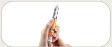 A hand holding vertically an orange and silver injection pen with the letter 'l'