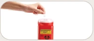 A hand holding a small white vial above a red cylindrical container with yellow label and biohazard symbol