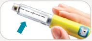 A hand gripping a cylindrical yellow medical device with transparent reservoir and a blue arrow pointing downward