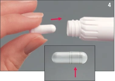 Una mano sostiene una cápsula blanca que se inserta en un recipiente cilíndrico blanco con una vista detallada de la cápsula misma