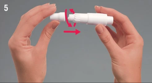 Dos manos sostienen un dispositivo médico blanco girándolo en sentido horario como indica una flecha roja curva y una flecha recta
