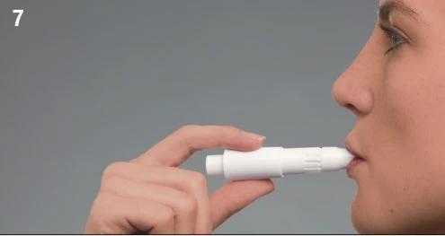 Perfil de una persona que sostiene un dispositivo médico blanco entre los labios para la