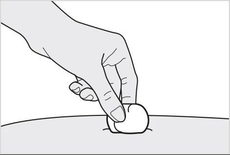 A hand gently presses a cotton swab or gauze pad onto the skin surface over a small bump or wound