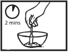A hand holds a bottle above a bowl containing liquid and a timer indicates a waiting time of 2 minutes