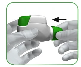 Two gloved hands holding a white and green medical device while a black arrow indicates a sliding movement to the left