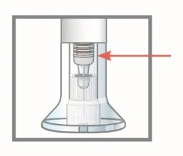 Diagram techniczny przezroczystego urządzenia medycznego z czerwoną strzałką wskazującą górną część mechanizmu wewnętrznego