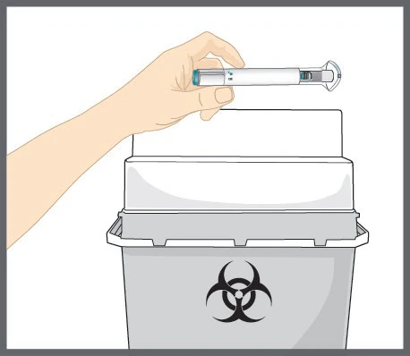 Dłoń trzyma białe pióro-injektor nad szarym pojemnikiem na odpady biologiczne z czarnym symbolem zagrożenia biologicznego