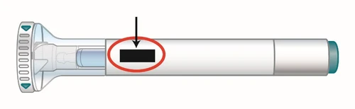 Poziomy diagram białego cylindrycznego urządzenia medycznego z czarną strzałką wskazującą na otoczony czerwonym kołem czarny prostokąt
