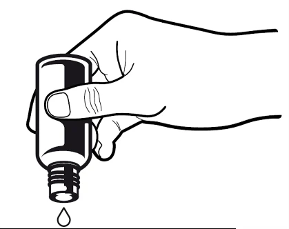 Una mano sostiene un frasco vertical con la tapa quitada, de la cual cae una sola gota de líquido hacia abajo