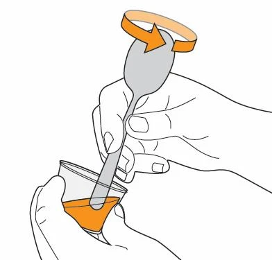 One hand holds a small glass with orange liquid while the other