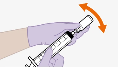 A gloved hand holding a tilted syringe, with a curved orange arrow indicating a counterclockwise rotational movement
