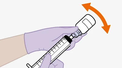 A gloved hand holding a syringe while preparing for injection
