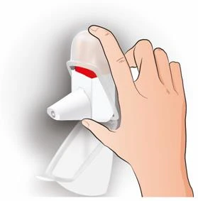 Una mano sostiene un dispositivo médico blanco con tapa transparente y una parte interna roja sobre fondo blanco