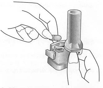 Two hands prepare a medical device by inserting a small capsule into a cylindrical container with a snap mechanism