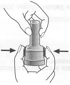 A hand holds a medical device vertically while a