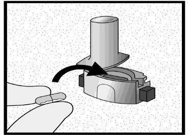 A hand inserts a white capsule into the