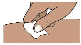 A hand presses a white cotton ball onto the surface of brown skin to disinfect or treat the area