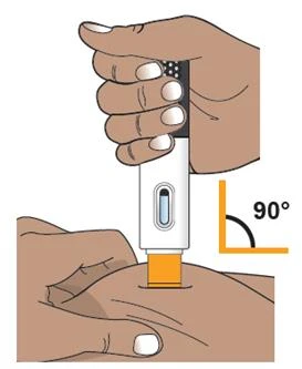 A hand with dark skin holds a black and white medical device to inject it into the skin of a