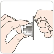 Dos manos que sostienen y separan cuidadosamente los dos componentes de un dispositivo médico de plástico transparente y gris sobre fondo blanco
