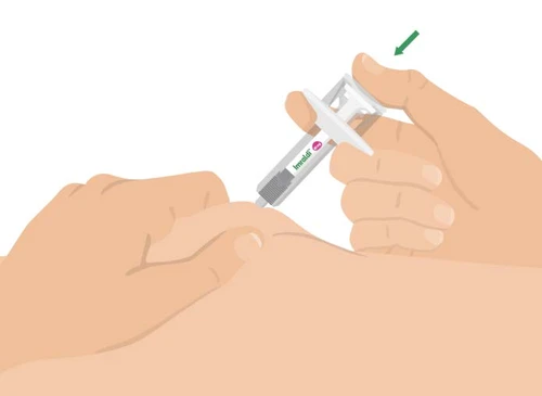 Dos manos sostienen una jeringa precargada para aplicarla sobre la piel del brazo con una flecha verde que indica la dirección de la presión
