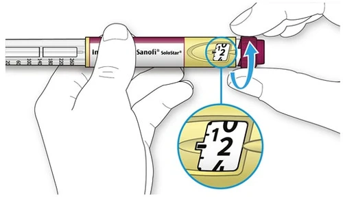 Manos que giran la parte terminal de una pluma inyectora Sanofi SoloStar con un aumento que muestra el número 12 en la pantalla amarilla