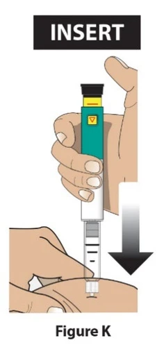 Una mano sostiene verticalmente un dispositivo médico de color verde y blanco para insertarlo en la piel siguiendo la dirección de una flecha negra