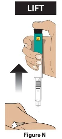 Una mano sostiene verticalmente un dispositivo médico cilíndrico blanco y verde para levantarlo hacia la