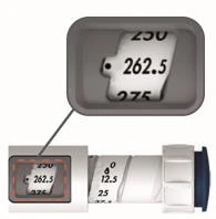 Detail of a dosage on a syringe with a numerical scale showing the values 250, 262.5, and 275 highlighted in an enlarged box