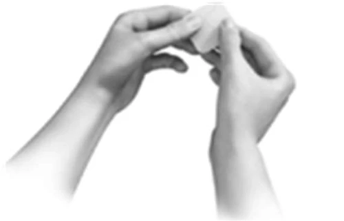 Two hands hold and gently separate a small white rectangular object against a neutral background