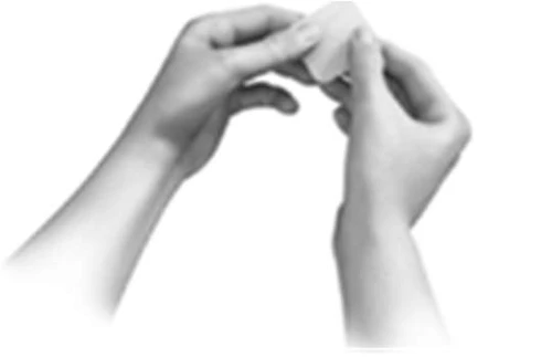 Two hands hold and carefully open a small container or pouch made of light material against a neutral background