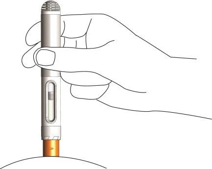 A hand holding vertically a gray and white cylindrical medical device with an orange lower part above a white curved surface