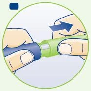 Dos manos sostienen un dispositivo médico cilíndrico verde y azul con una flecha azul que indica el movimiento de rotación hacia la derecha