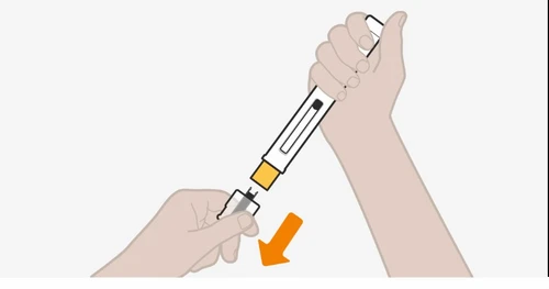 A hand holding a white medical device while the