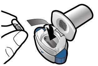 A hand holding a white and blue medical device with an open cap revealing an internal mechanism and a grid surface