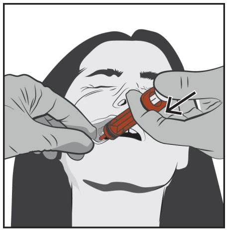 Two hands hold an orange medical device applying it to a person's cheek with a black arrow indicating the direction of pressure