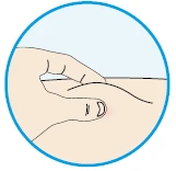 A finger gently pressing on a slightly reddened area of skin on the