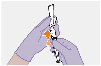 Gloved hands drawing liquid from a glass vial using a syringe following the direction of an orange arrow pointing left